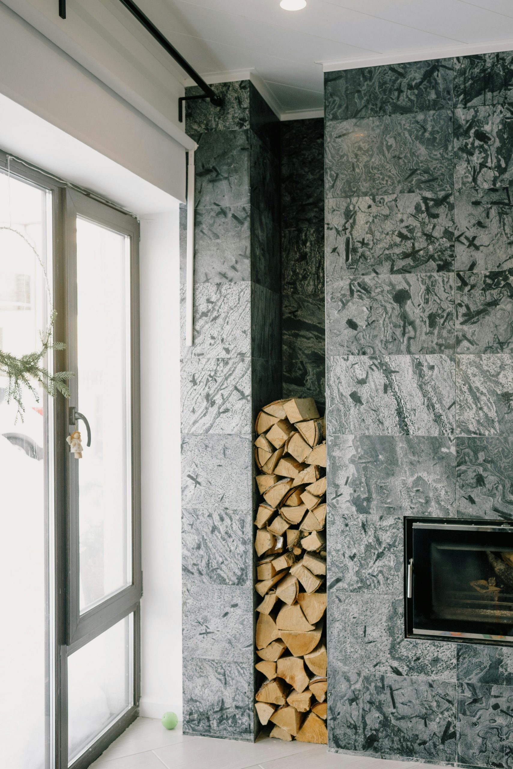 Cozy modern living room featuring a sleek fireplace and a neatly stacked woodpile.