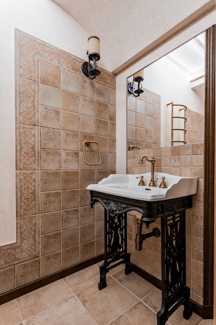 Stylish vintage-style bathroom with ornate sink, tiled walls, and classic fixtures.